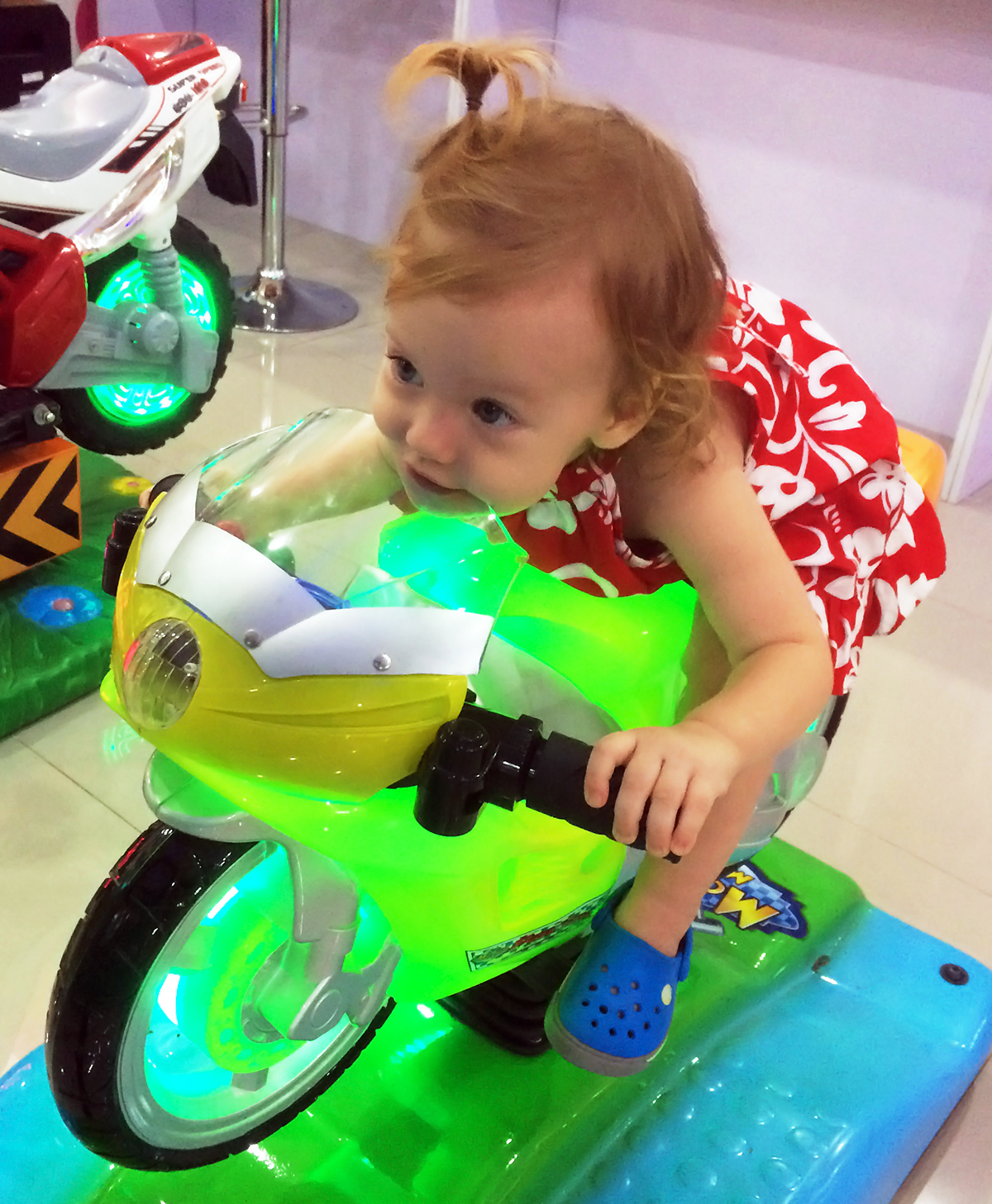 Olivia racing on toy bike. Where's Your Helmet Girl?